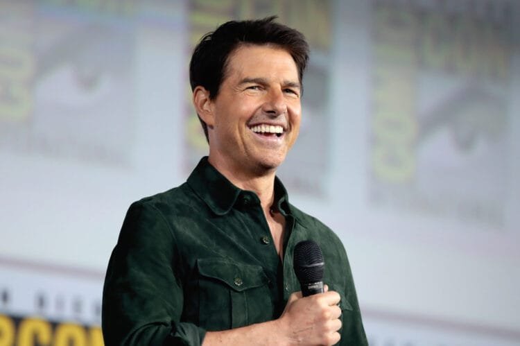 Tom Cruise smiling at a movie premiere, representing his Hollywood success and charisma.